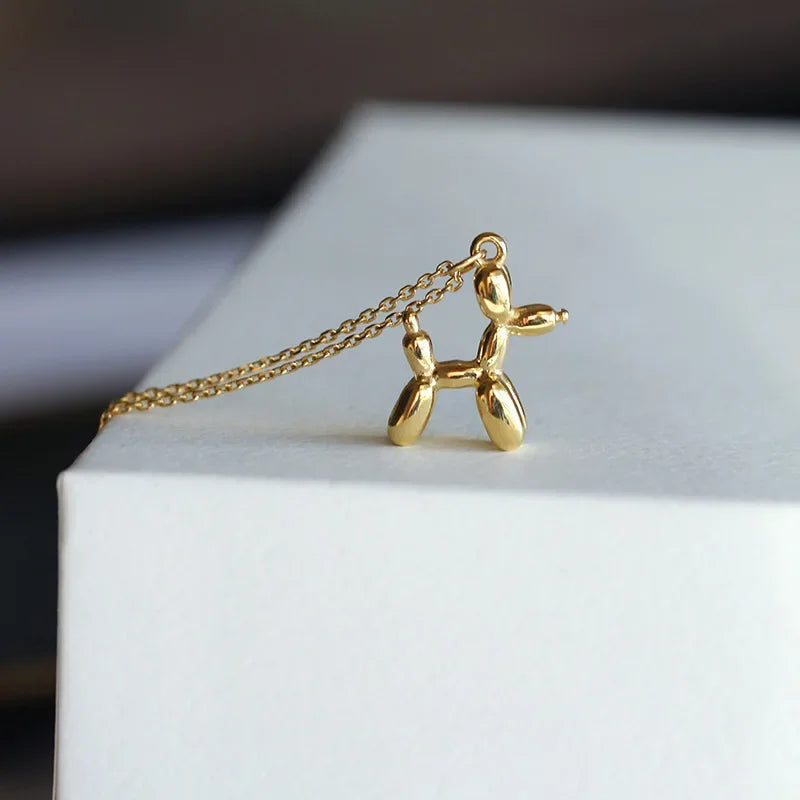 Collar con colgante en forma de perro globo de color dorado